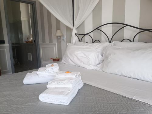 a bed with three towels sitting on top of it at Relais Tiaré Bed and Breakfast in Bacoli
