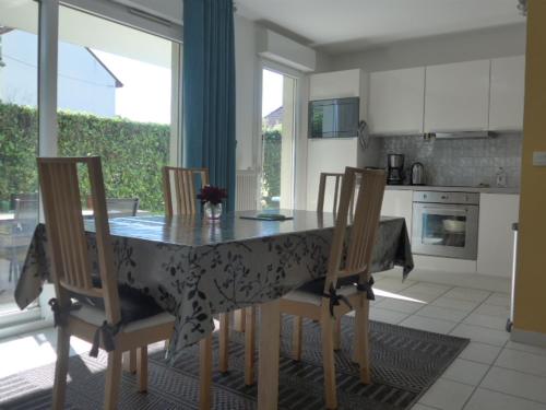 une cuisine avec une table, des chaises et un tissu de table dans l'établissement COOL, à Thonon-les-Bains