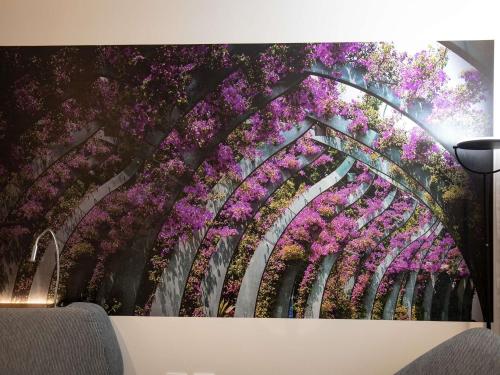 a painting of a bridge with flowers on a wall at Novotel Brisbane South Bank in Brisbane