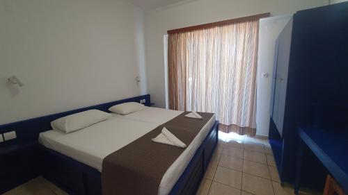 a hotel room with a bed and a window at Filoxenia Apartments & Studios in Theologos