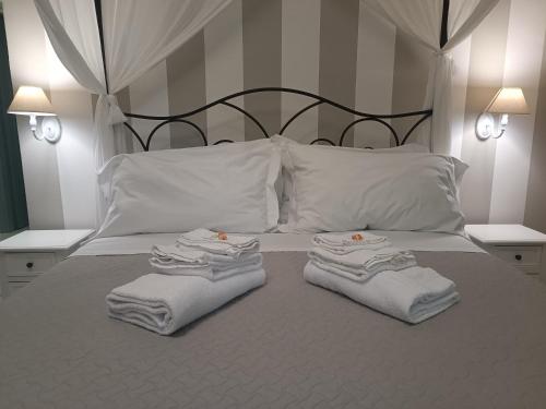 a bed with white towels and pillows on it at Relais Tiaré Bed and Breakfast in Bacoli