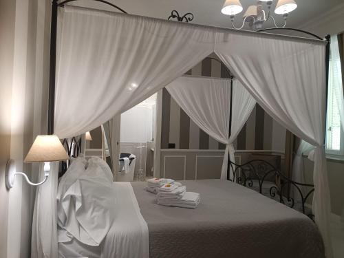 a bedroom with a canopy bed with white curtains at Relais Tiaré Bed and Breakfast in Bacoli