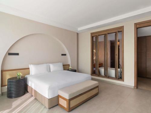 a bedroom with a white bed and a large window at Rixos The Palm Hotel & Suites - Ultra All Inclusive in Dubai