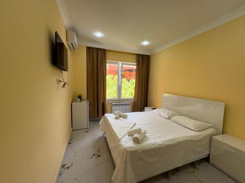 a bedroom with a bed with white sheets and a window at R Hotel Yerevan in Yerevan