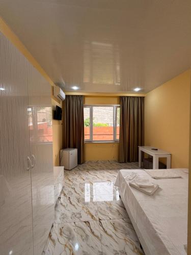 a large room with a bed and a glass wall at R Hotel Yerevan in Yerevan
