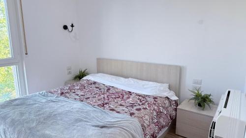 a bedroom with a bed with a pink and white blanket at Vala Mar Apartments by Four C in Hamallë