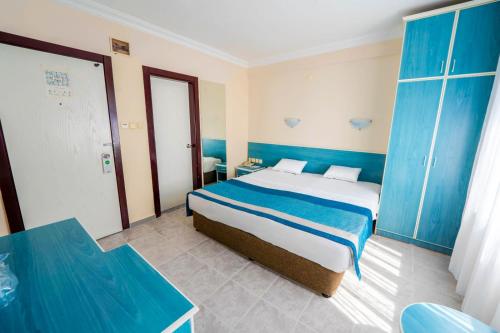 a bedroom with a large bed and blue cabinets at Galaxy Beach Hotel Alanya in Mahmutlar