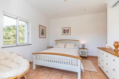 a bedroom with a white bed and a window at Villa Serena-gorgeous Rural Family Villa & Pool in Morenos