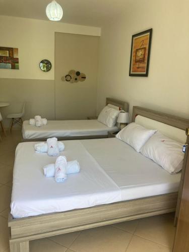 two beds in a hotel room with towels on them at Vacanze Pushime Albania in Radhimë