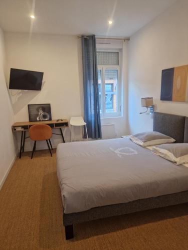 une chambre avec un lit et un bureau dans l'établissement APPART'HOTEL CASA Patricia, à Béthune