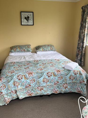 a bedroom with a bed with a colorful bedspread at Green Hayes Estate Rentals - Green Hayes Cabin in Temuka