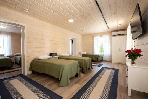 een kamer met 2 bedden en een tv. bij Villa Ruuska 