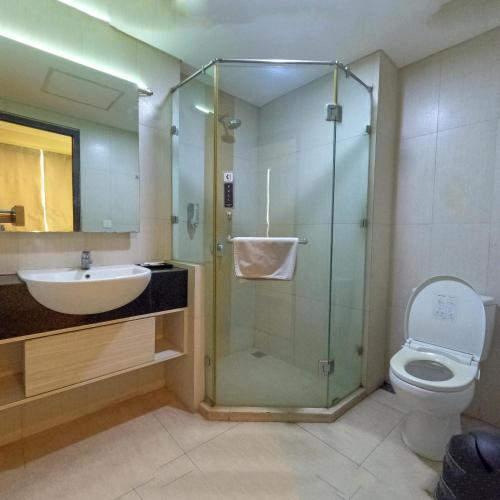 a bathroom with a shower and a toilet and a sink at World Hotel Jakarta - Bandengan in Jakarta
