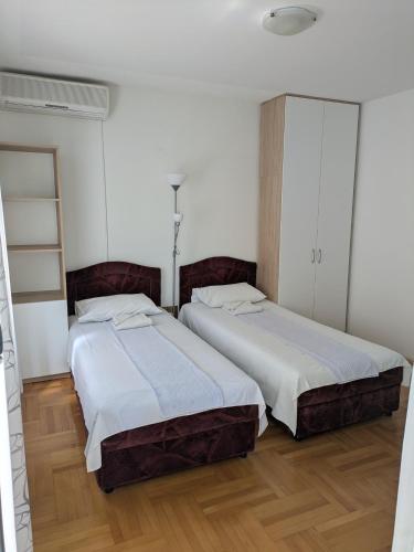 two beds sitting next to each other in a room at Apartmani Abeona in Budva