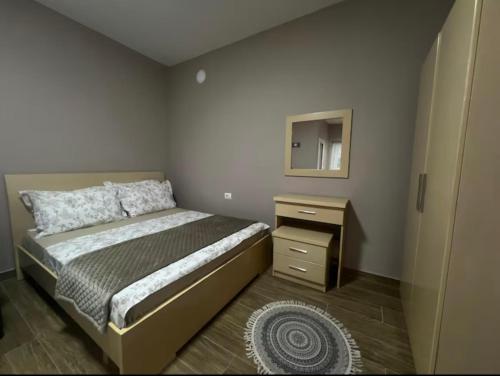 a bedroom with a bed and a dresser and a mirror at Vjollcas guesthouse in Pogradec