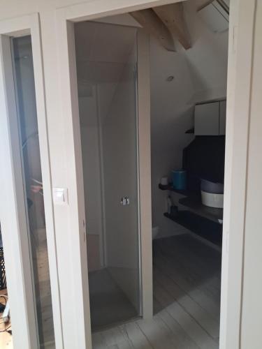 une porte en verre menant à une chambre avec une cuisine dans l'établissement Grande maison sur propriété près de la plage de Morgat, à Crozon