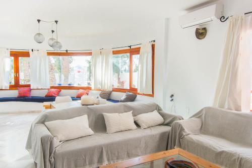 a living room with two gray couches and windows at Casa Sol, Rodalquilar in Rodalquilar