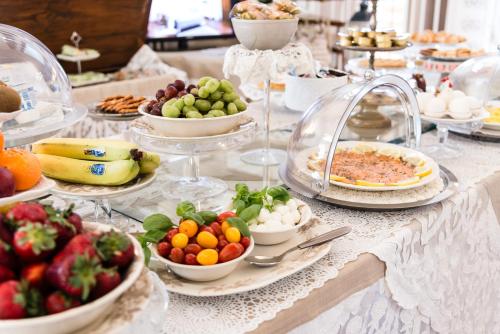 a table topped with plates of food and bowls of fruit at Giardino della Pieve Relais- Adult Only in Cascina