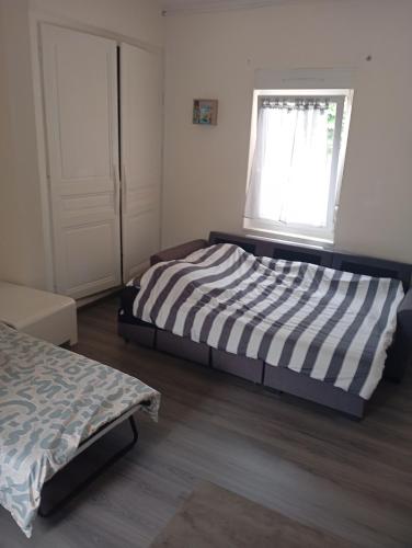 une chambre avec deux lits et une fenêtre dans l'établissement Studio prox tram métro et périphérique, à Vénissieux