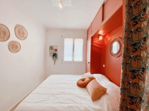 une chambre avec un grand lit blanc avec des murs orange dans l'établissement T2 Unique Vue mer et accès plage - 43, à Canet
