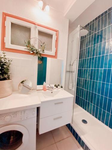 une salle de bain blanche avec un lavabo et une douche dans l'établissement T2 Unique Vue mer et accès plage - 43, à Canet