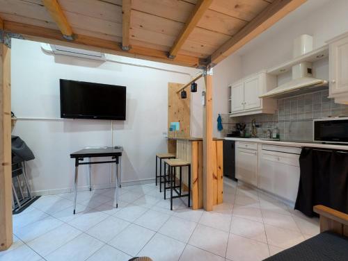 Il comprend une cuisine avec une table et une télévision murale. dans l'établissement Studio de 4 couchages à 100m de la mer, à Fréjus