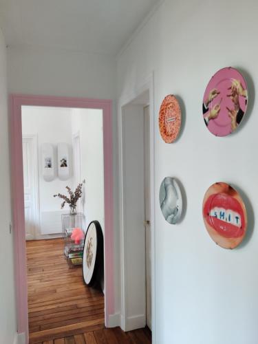 une pièce avec un couloir avec un miroir et des assiettes au mur dans l'établissement Appartement design, parisien très lumineux, à Maisons-Alfort