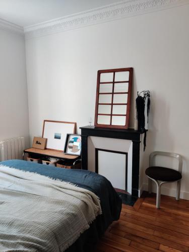 une chambre avec un lit et une cheminée dans l'établissement Appartement design, parisien très lumineux, à Maisons-Alfort