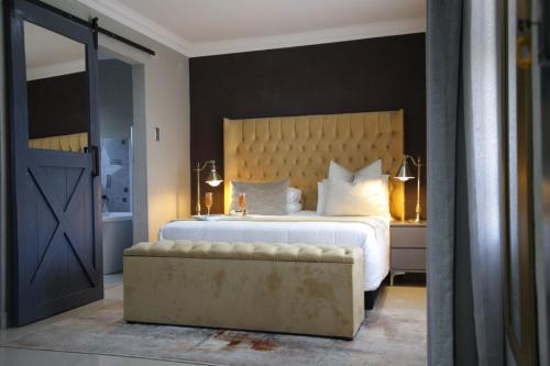 une chambre avec un grand lit avec une grande tête de lit dans l'établissement The Village GuestHouse, à Acornhoek