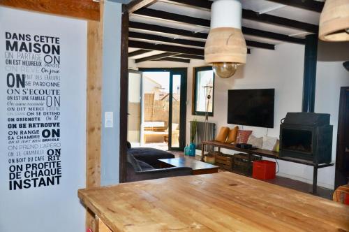 un salon avec une table et une télévision dans l'établissement Loft a 15 minutes à pied du centre et 5 du tramway, à Montpellier