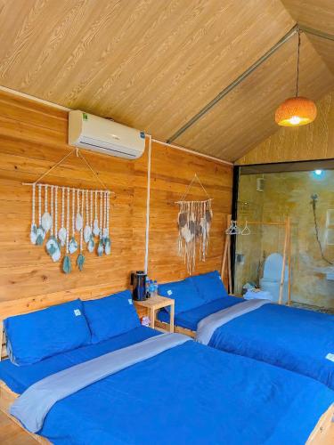 a room with three beds with blue sheets at Lacasa home&coffee Mộc Châu in Mộc Châu