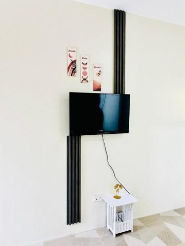 a living room with a tv on a wall at BossBabe Nacpan Beach House in El Nido