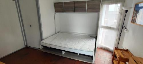 une petite chambre avec un lit dans une pièce dans l'établissement La plage, à Saint Cyprien Plage