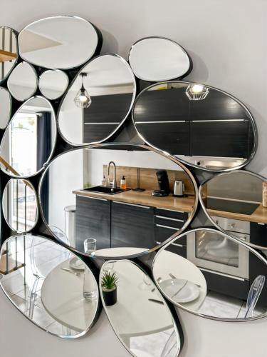 un grand miroir circulaire sur le mur d'une cuisine dans l'établissement Le Bel Ouvillais - Proche Plage & Chemins Rando, à Ouville-la-Rivière