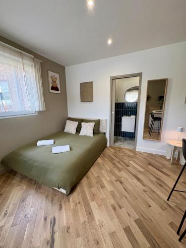 une chambre avec un lit et un parquet dans l'établissement Le Studio, à Anstaing