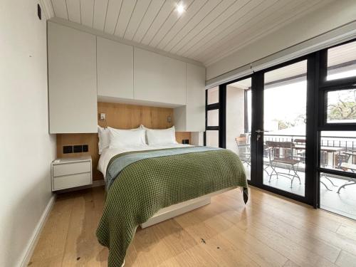 Un dormitorio con una cama y una ventana grande. en Modern living in central town, en Stellenbosch