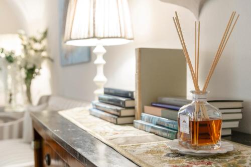 a table with a bottle of whiskey and a stack of books at Giardino della Pieve Relais- Adult Only in Cascina