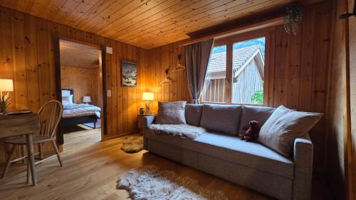 a living room with a couch and a bedroom at Alpine Loft, Central, Balcony, Parking, Family,PS5 in Frutigen