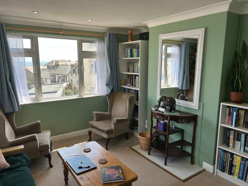 a living room with a couch and a table and a window at Cosy flat by Penzance harbour in Penzance