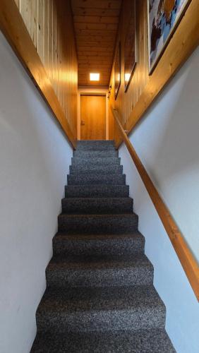 a staircase leading up to a building with wooden ceilings at Alpine Loft, Central, Balcony, Parking, Family,PS5 in Frutigen