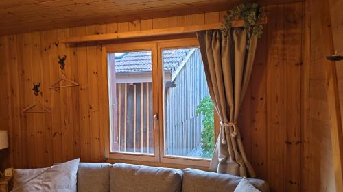 a living room with a couch and a window at Alpine Loft, Central, Balcony, Parking, Family,PS5 in Frutigen