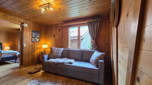 a living room with a couch and a window at Alpine Loft, Central, Balcony, Parking, Family,PS5 in Frutigen