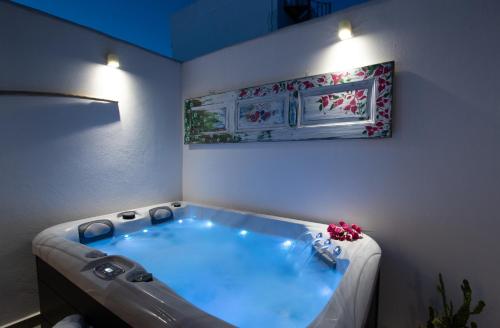 a bath tub in a room with a painting on the wall at Koskinou Traditional Houses in Koskinou