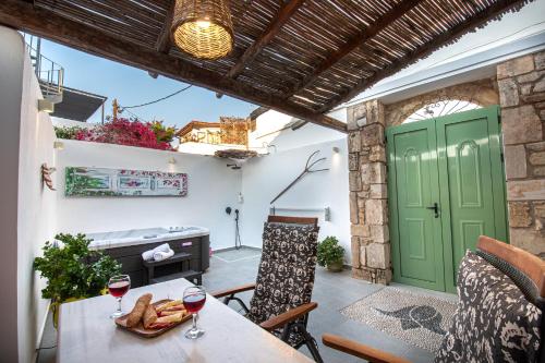 a patio with a table and two glasses of wine at Koskinou Traditional Houses in Koskinou