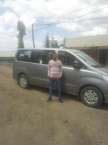 a man standing in front of a van at Amazing Lalibela Home stay in Lalībela