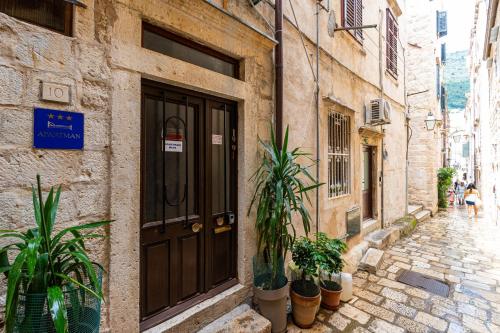 un edificio con una puerta y plantas en una calle en Apartman Neve, en Dubrovnik