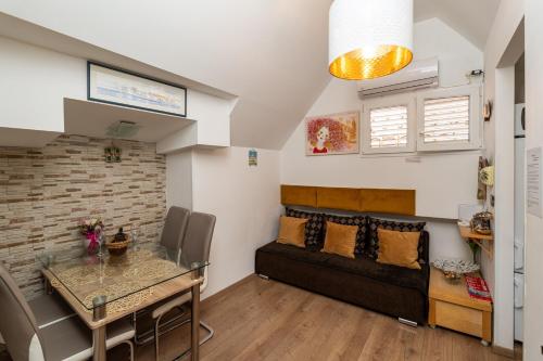 una sala de estar con un sofá y una mesa en Apartman Neve, en Dubrovnik