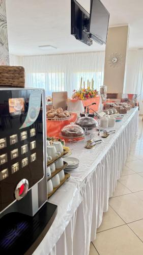 a long white table with food on it at Ibisco Hotel in Rodi Garganico