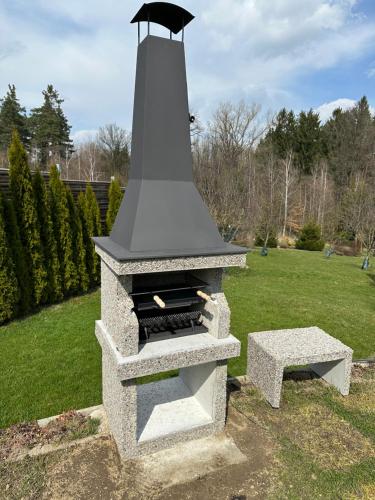 a stone stove with a bench in a yard at Vila u potoka in Jindrichuv Hradec