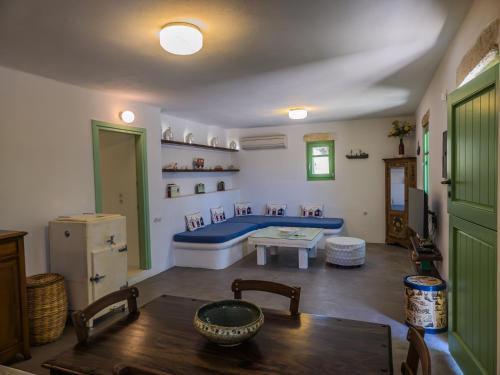 a living room with a blue couch and a table at Maravites Cottage in Zefiría
